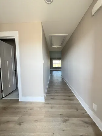 a view of a hallway with wooden floor