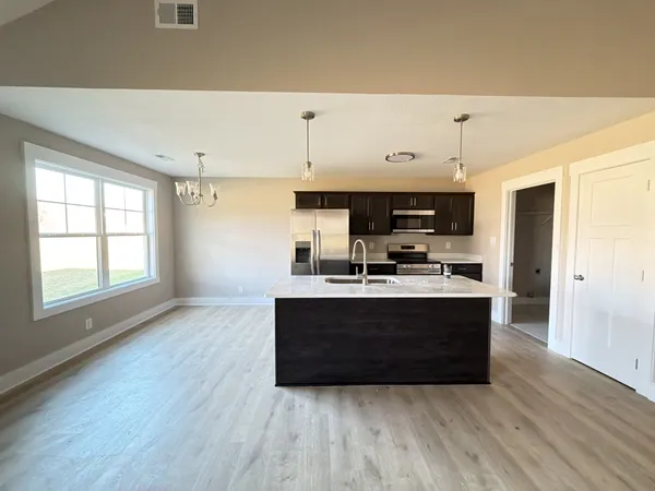 a view of kitchen with stainless steel appliances granite countertop a stove and a refrigerator