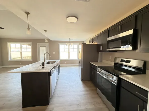 a kitchen with stainless steel appliances kitchen island a sink stove and cabinets