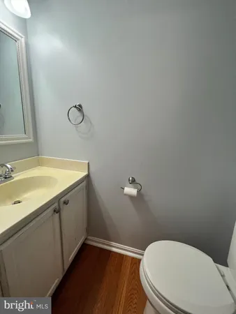 a bathroom with a granite countertop toilet sink and mirror
