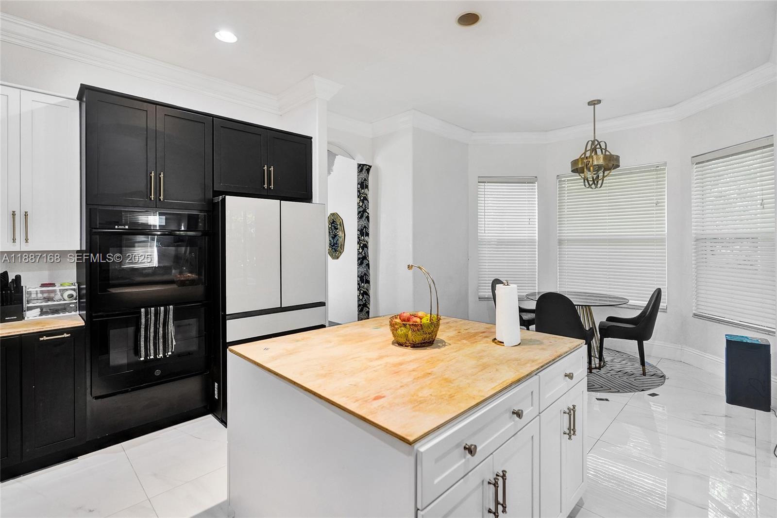 8824 Cobblestone Point Circle Boynton Beach, FL 33472 - Photo 15 of 53 a kitchen with a table chairs refrigerator and cabinets