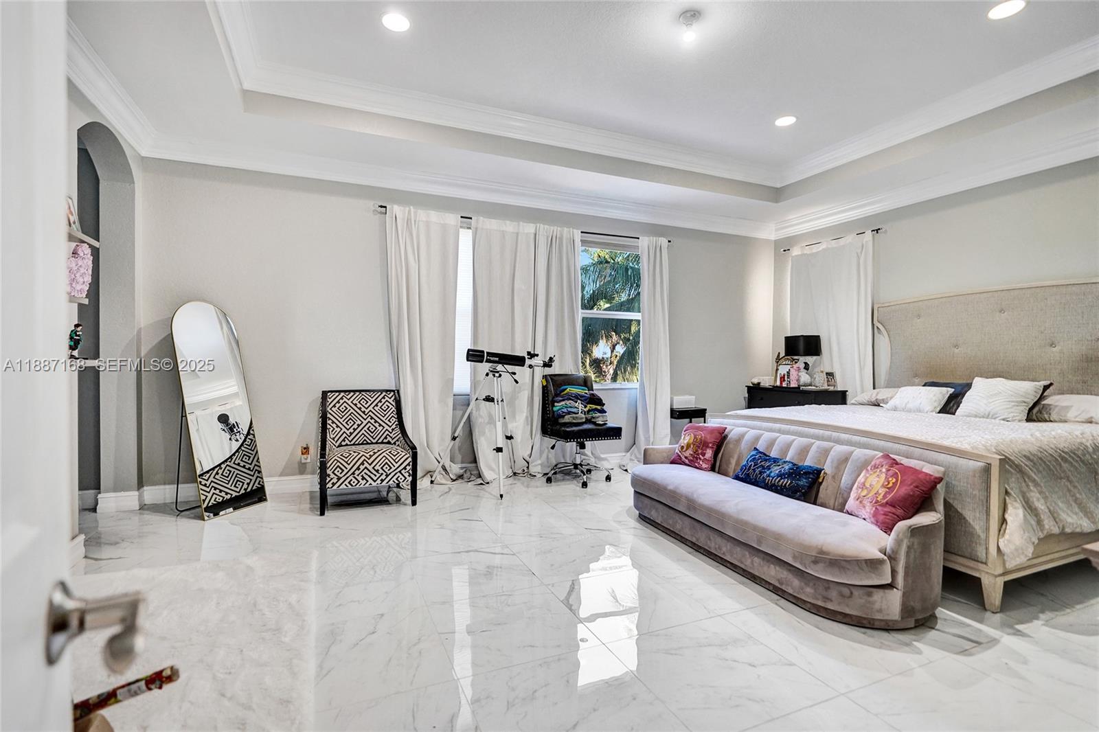 8824 Cobblestone Point Circle Boynton Beach, FL 33472 - Photo 32 of 53 a spacious bedroom with a bed a table and gym equipment