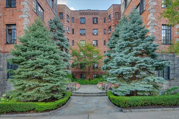 a view of a building and garden with large trees