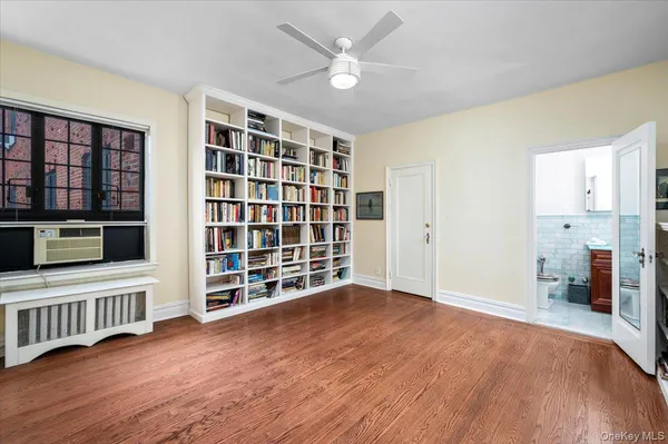 a view of an empty room with a window and wooden floor