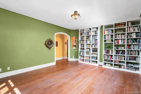a view of empty room with windows and book shelf