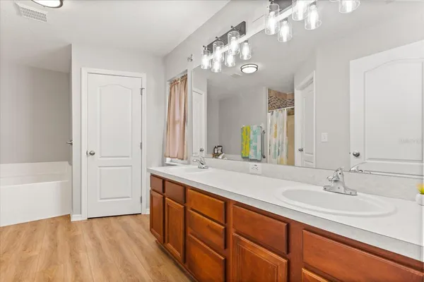 a bathroom with a sink double vanity granite tub and a mirror