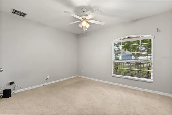 an empty room with a window and a fan