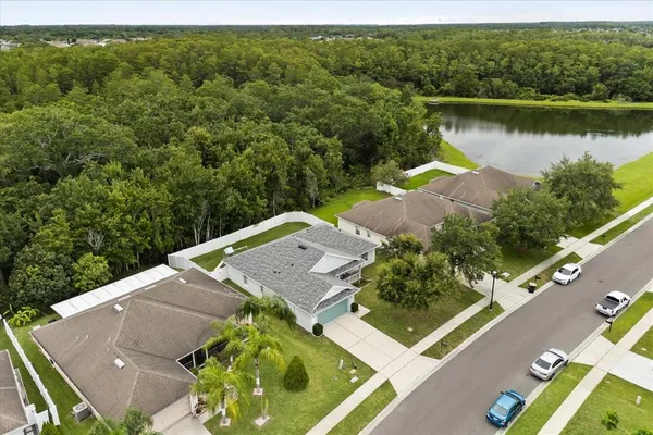 an aerial view of a house with a garden and lake view