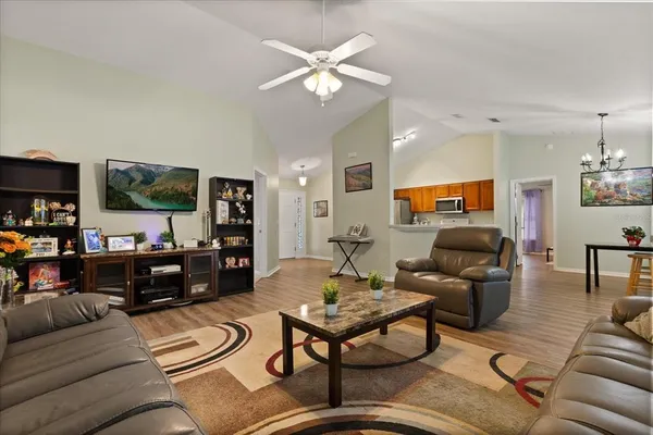 a living room with furniture kitchen view and a flat screen tv