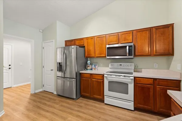 a kitchen with a refrigerator stove and wooden cabinets