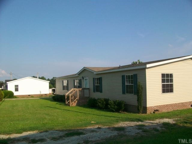 8035 Wiggins Mill Road Lucama, NC 27851 - Photo 4 of 5 a front view of a house with garden