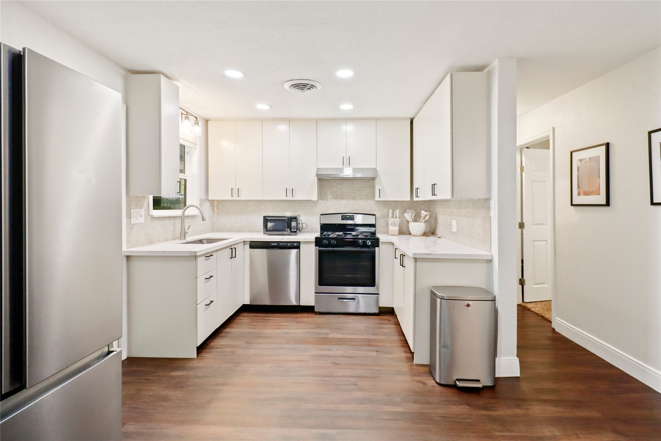 916 North Chenango Street Angleton, TX 77515 - Photo 3 of 15 a kitchen with white cabinets stainless steel appliances and sink
