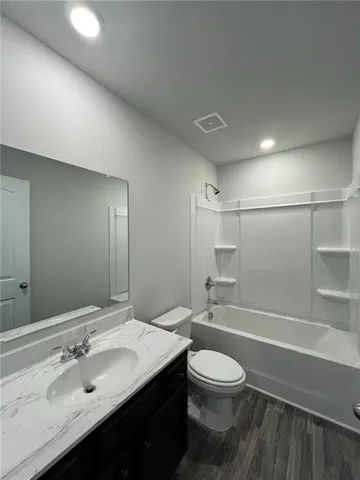 a bathroom with a granite countertop sink toilet a large mirror and shower