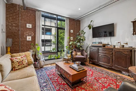 a living room with furniture a flat screen tv and a large window