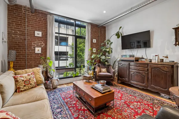 a living room with furniture a flat screen tv and a large window