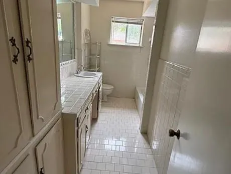 a bathroom with a granite countertop shower a sink and a toilet