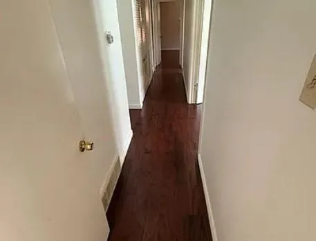 a view of a hallway with wooden floor and staircase