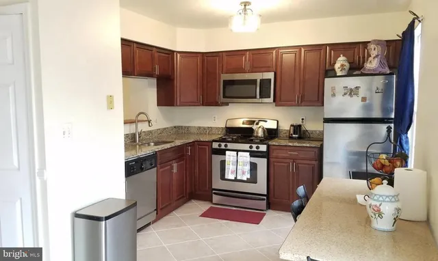 a kitchen with stainless steel appliances granite countertop a refrigerator stove microwave and sink
