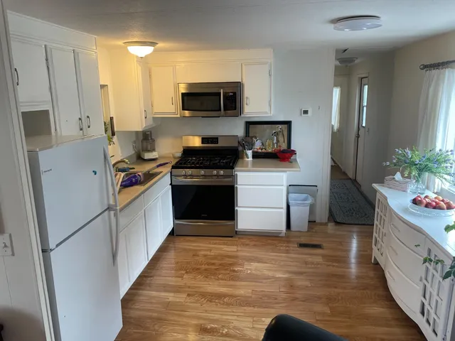 a kitchen with stainless steel appliances a stove refrigerator sink and wooden cabinets
