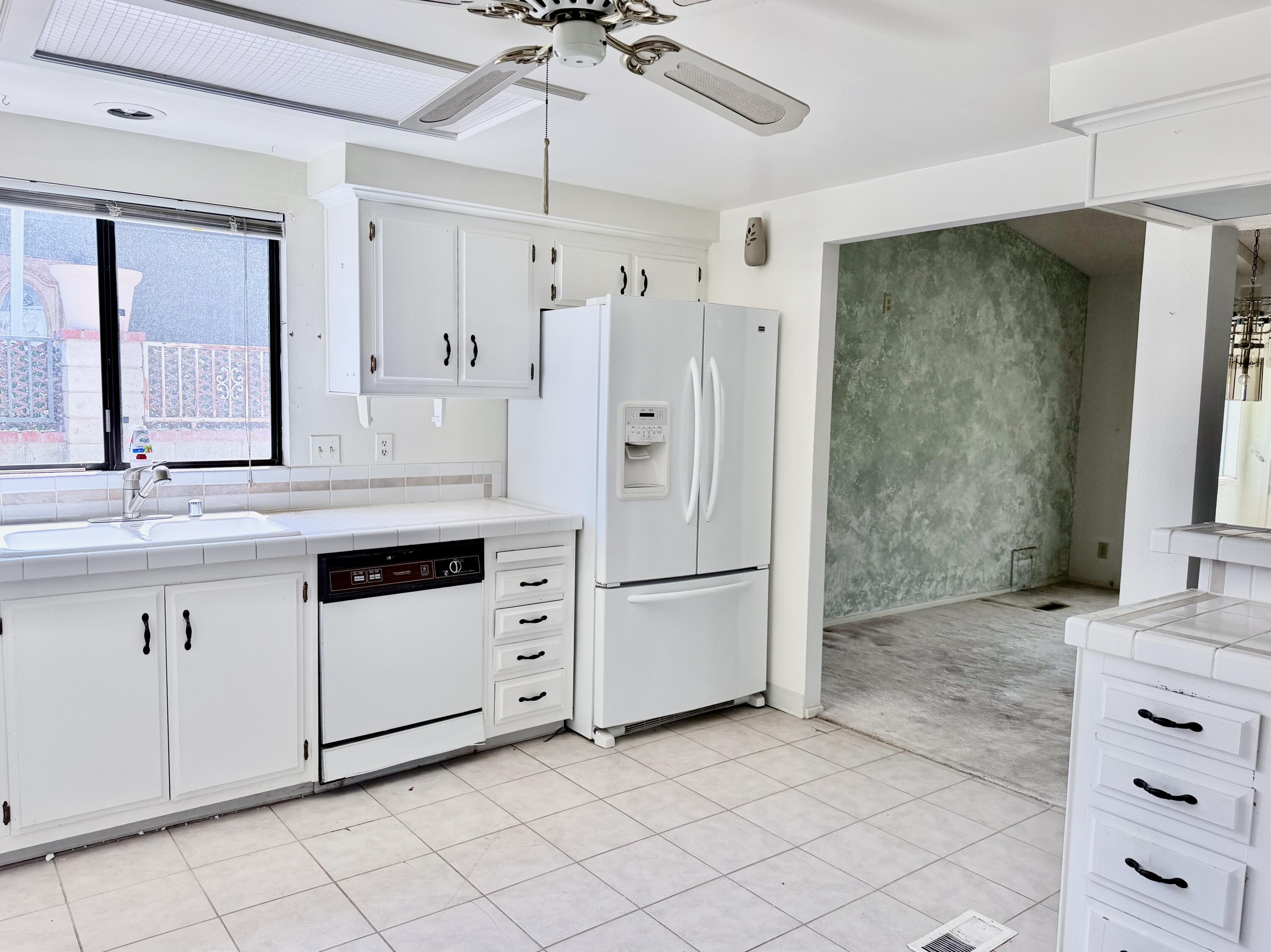 74361 Angel Camp Road Palm Desert, CA 92260 - Photo 5 of 12 a kitchen with granite countertop white cabinets and white appliances