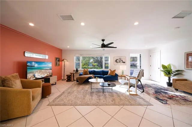 a living room with fireplace furniture and a large window