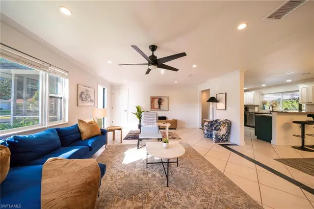 a living room with furniture kitchen view and a large window