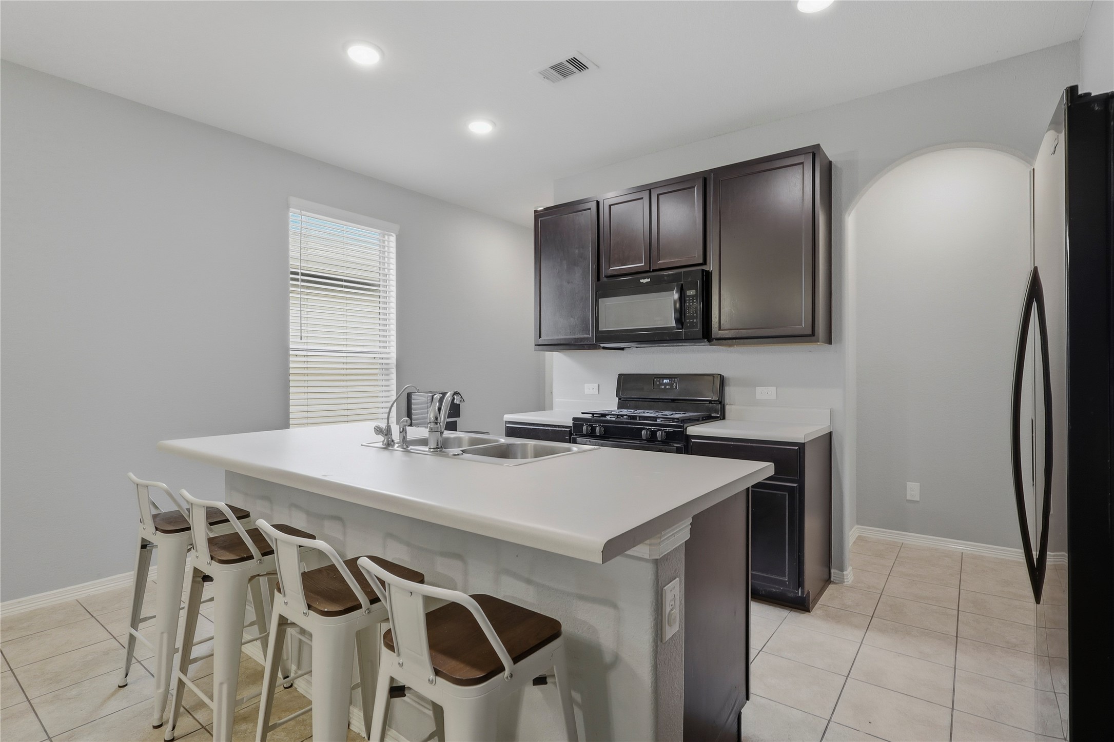 9938 Yanet Grove Lane Houston, TX 77044 - Photo 6 of 21 a kitchen with a sink a stove a refrigerator and cabinetry