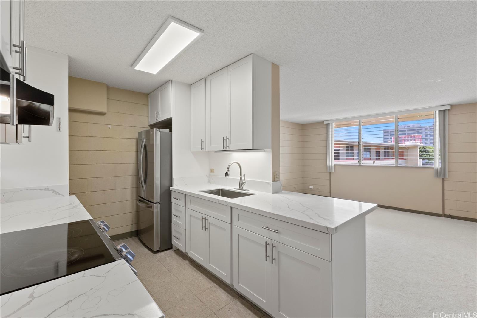 633 Nalanui Street, Unit 409 Honolulu, HI 96817 - Photo 4 of 15 a kitchen with a sink and refrigerator