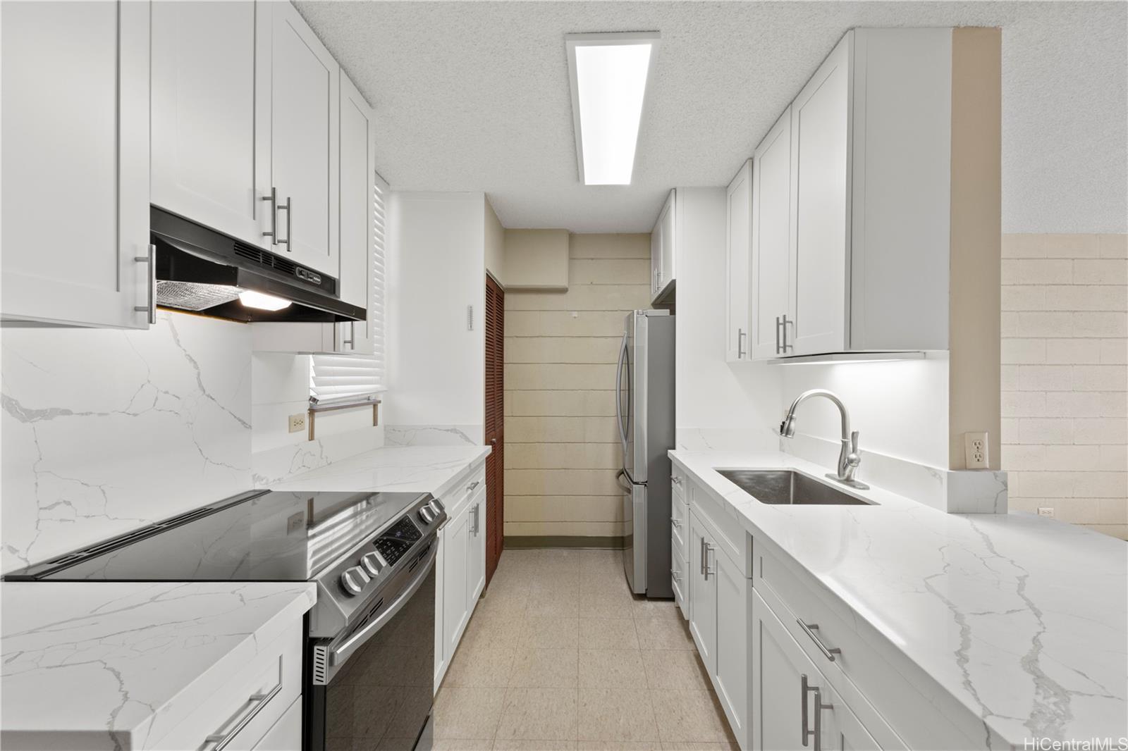 633 Nalanui Street, Unit 409 Honolulu, HI 96817 - Photo 5 of 15 a kitchen with a sink and a stove top oven