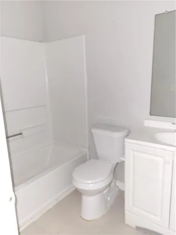 a white toilet sitting next to a bath tub
