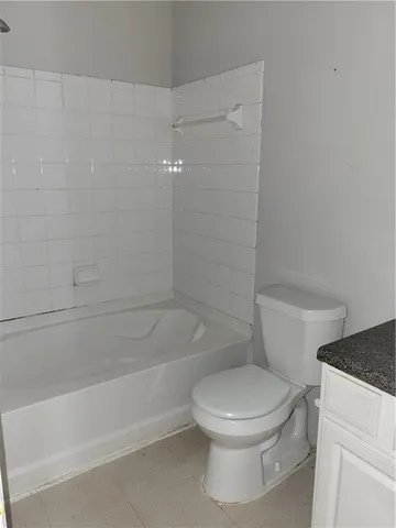 a white toilet and tub sitting next to a bathroom sink