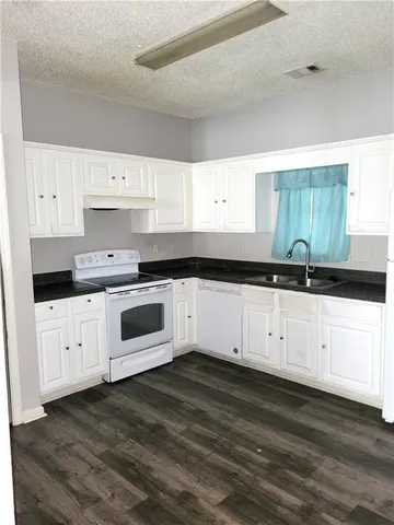 a white kitchen with granite countertop white cabinets and a granite counter tops