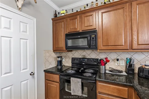 a kitchen with granite countertop cabinets stainless steel appliances and wooden cabinets