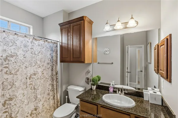 a bathroom with a granite countertop sink and a mirror