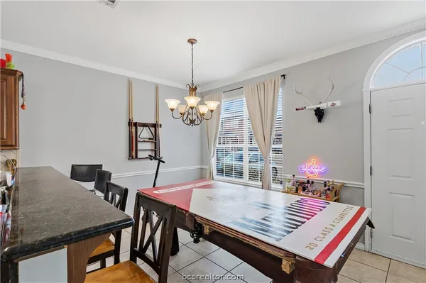 a view of a dining room with furniture and chandelier
