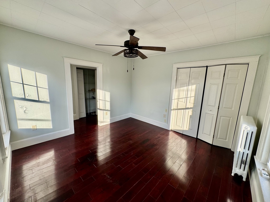6 Gould Street, Unit 2 Stoneham, MA 02180 - Photo 11 of 27 a view of an empty room with wooden floor and a window