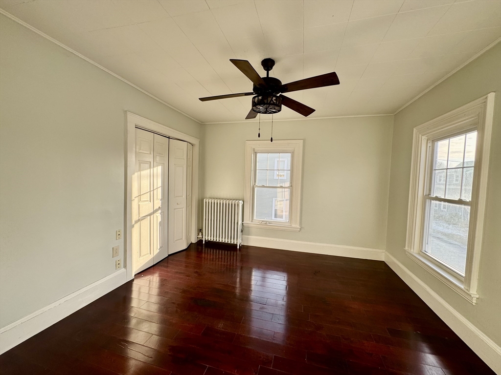 6 Gould Street, Unit 2 Stoneham, MA 02180 - Photo 12 of 27 a view of an empty room with wooden floor and a window