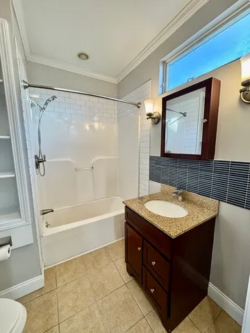 a bathroom with a sink a toilet a mirror and bathtub