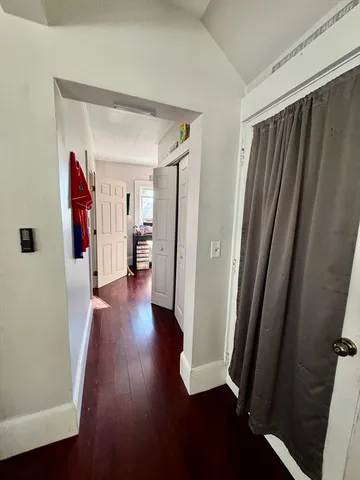 a view of a hallway with wooden floor and stairs