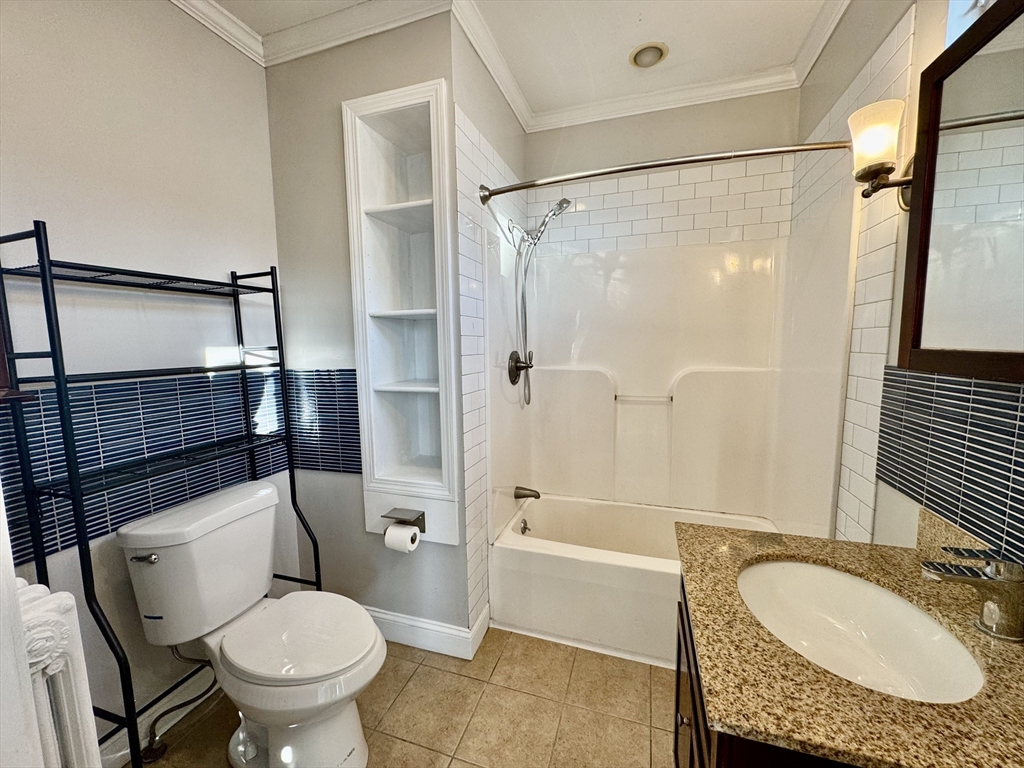 6 Gould Street, Unit 2 Stoneham, MA 02180 - Photo 15 of 27 a bathroom with a granite countertop toilet sink and shower