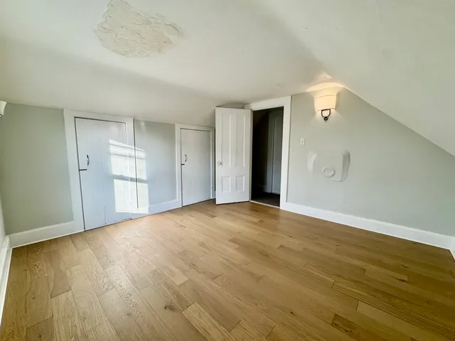 a view of empty room with wooden floor and space
