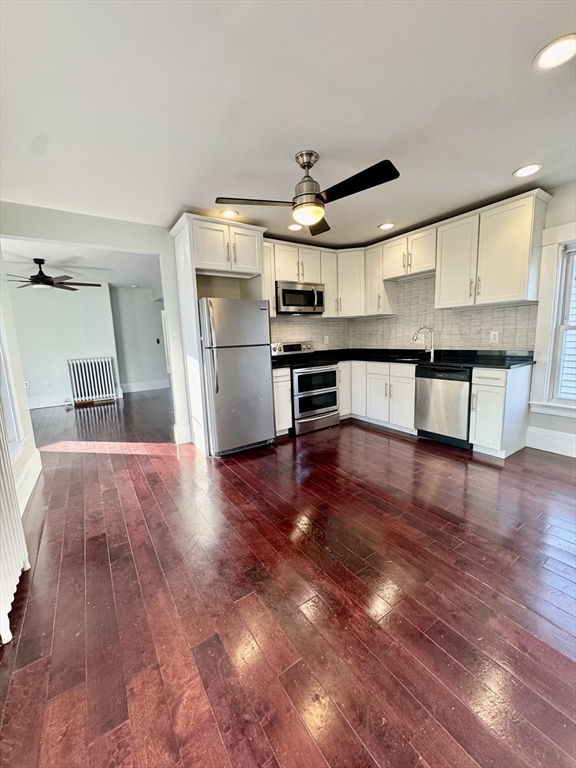 6 Gould Street, Unit 2 Stoneham, MA 02180 - Photo 4 of 27 a kitchen with stainless steel appliances a refrigerator and wooden floor