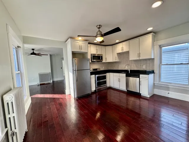 a kitchen with stainless steel appliances a stove a refrigerator and a hard wood floor
