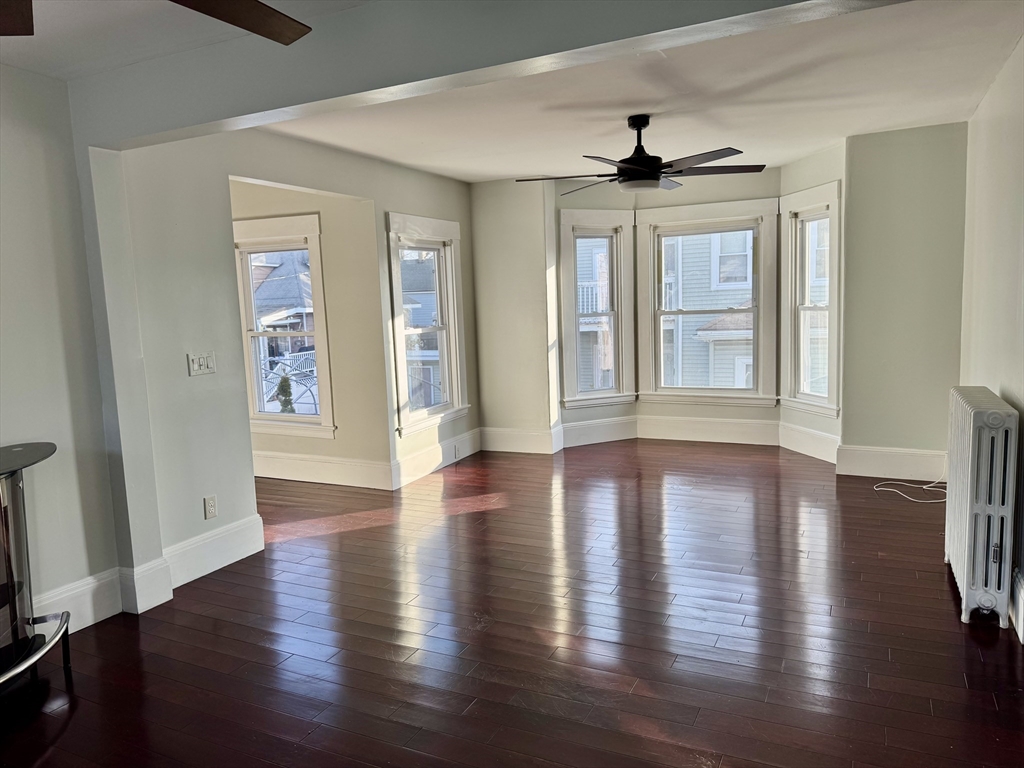 6 Gould Street, Unit 2 Stoneham, MA 02180 - Photo 7 of 27 a view of an empty room with wooden floor and a window