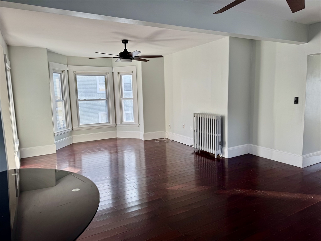 6 Gould Street, Unit 2 Stoneham, MA 02180 - Photo 8 of 27 a view of an empty room with wooden floor and a window