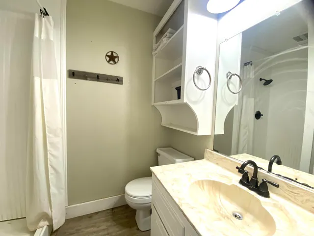 a bathroom with a granite countertop sink toilet and shower