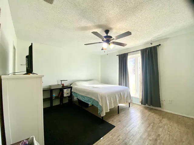 a spacious bedroom with a bed and a chandelier