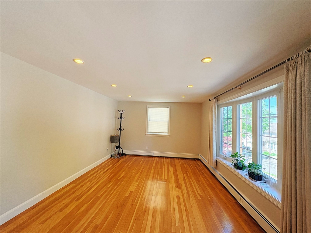 55 Sutherland Road, Unit 55 Arlington, MA 02476 - Photo 5 of 23 a view of empty room with wooden floor and fan