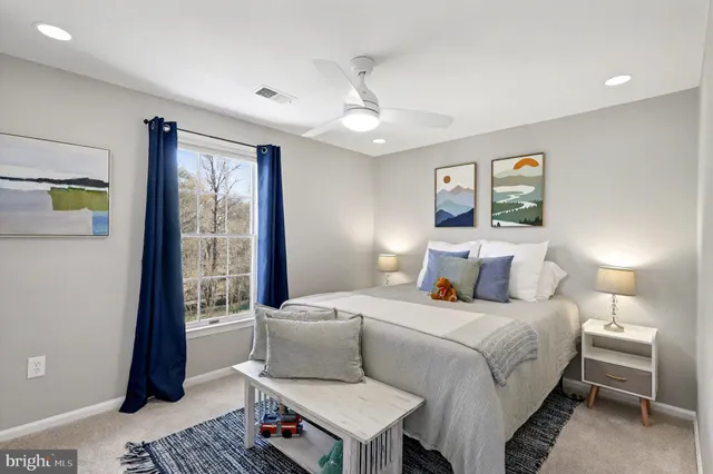 a spacious bedroom with a bed a table and a potted plant