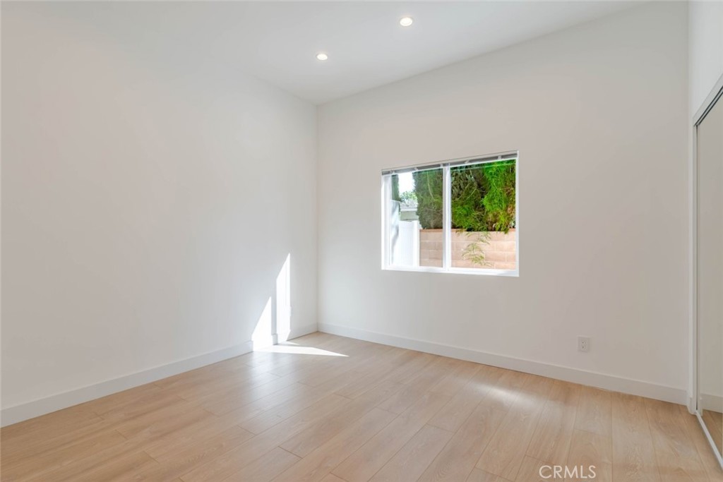 6852 Ranchito Avenue Van Nuys, CA 91405 - Photo 11 of 18 an empty room with wooden floor and windows